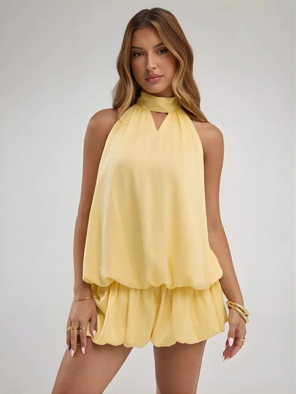 Modelo vestindo o Vestido Mini Ravello Amarelo Solar da BIANC, destacando o decote frente única com detalhe vazado e a saia fluida com babados.